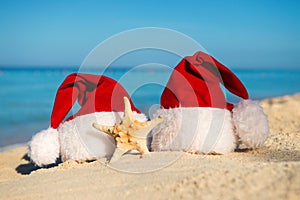 Romantic New Year at Sea. Christmas vacation. Santa hats on sandy beach