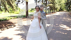 Romantic newly married couple dancing waltz in the park on their wedding day.