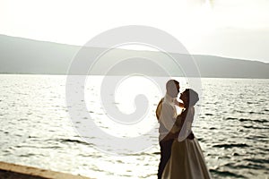 Romantic newlywed couple bride and groom at sunset beach near se