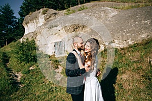 Romantic newlywed couple hugging near old mountain city. Love concept