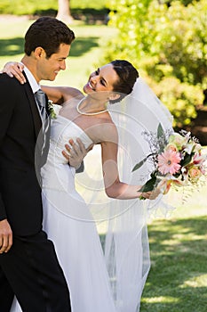 Romantic newlywed couple standing in park