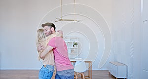 Romantic newlyweds with large brown cardboard boxes put things on floor pile in new apartment