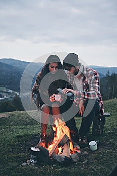 Romantic night. Beautiful young couple enjoying hot drinks while