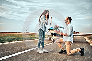 Romantic offer to get married. Man makes an offer to his girlfriend in airdrome photo