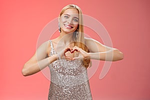 Romantic passionate charming lovely blond glamour woman in silver dress brilliants show heart love gesture express