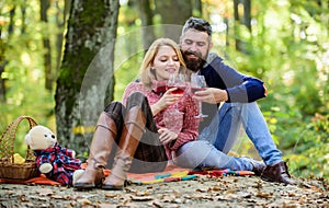 Romantic picnic with wine in forest. Couple in love celebrate anniversary picnic date. Couple cuddling drinking wine