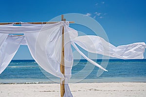 Romantic place by the sea. White fabric curtains fluttering in the wind.