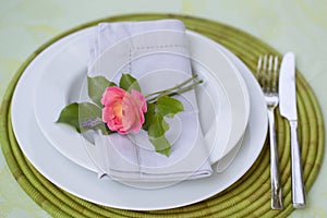 Romantic place setting with a single pink rose