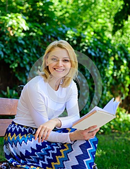 Romantic poem. Enjoy rhyme. Woman happy smiling blonde take break relaxing in garden reading poetry. Girl sit bench