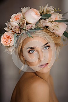 Portrait of the attractive topless blonde woman in a tender floral wreath