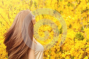 Romantic portrait of beautiful woman with long blowing hair on floral background