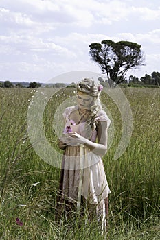 Romantic portrait of bohemian blonde in field of grass