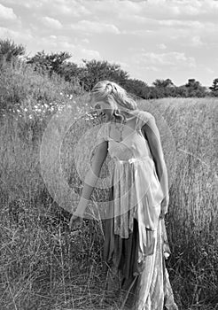 Romantic portrait of bohemian blonde in field of grass