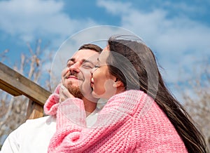 Romantic portrait of young married russian couple, woman kissing her husband