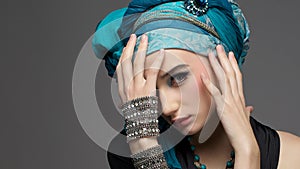 Romantic portrait of young woman in a turquoise turban with jewelry