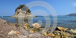 Romantic quiet beach with a small island on Elba island.