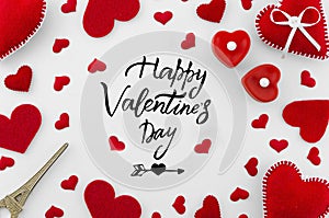 Romantic red flat lay composition on white background. Heart top view. Happy Valentines day hand lettering greeting card