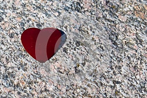 Romantic red love heart lying on a detailed granite background