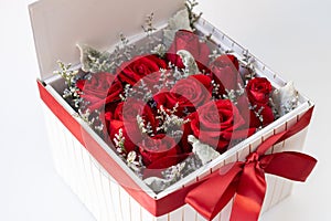 Romantic red roses in a square white gift box. on white background