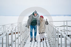 Romantic rendezvous of two lovers on valentine`s day on a pier on a frozen river