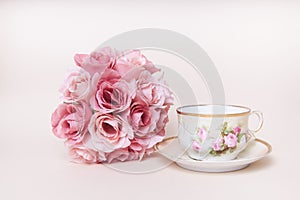 Romantic rose flower bouquet with antique tea cup with saucer