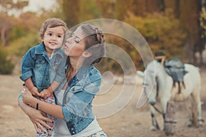 Romantic scene beautiful lady young mother with her cute baby daughter enjoy time together in city village park walking feeding wh photo