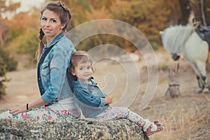 Romantic scene beautiful lady young mother with her cute baby daughter enjoy time together in city village park walking feeding wh photo