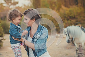 Romantic scene beautiful lady young mother with her cute baby daughter enjoy time together in city village park walking feeding wh