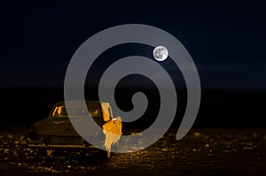 Romantic scene of old vintage car with couple inside and Moon on sky at night. Silhouette love and car on Full Moon Background. Se