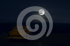 Romantic scene of old vintage car with couple inside and Moon on sky at night. Silhouette love and car on Full Moon Background. Se