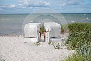 Romantic sea scene at white beach with beach chair at summer sunny day in north Germany