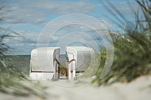 Romantic sea scene at white beach with wicker beach chair at summer sunny day