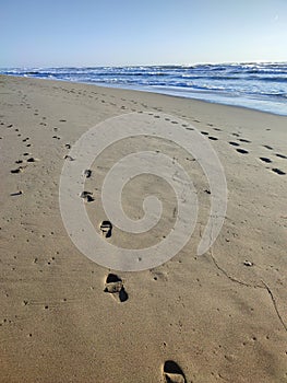 Romantic seascape on shoreline at deserted sandy beach in front of azure water