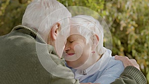 Romantic senior couple spending time in park on sunny autumn day