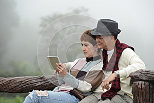 Romantic senior couples using digital tablet