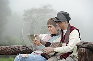 Romantic senior couples using digital tablet