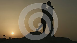 Romantic story of two people in love. Silhouette of couple kissing at sunset