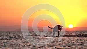 Romantic sunset at the beach, couple is kissing, silhouette, slow motion