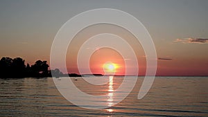 Romantic sunset over sea with swans swimming