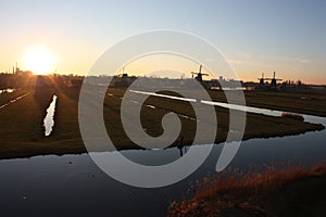 Romantic sunset in red and yellow colors. the plain of the rural countryside of zaanse schans with its typical Dutch mills