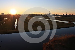 Romantic sunset in red and yellow colors. the plain of the rural countryside of zaanse schans with its typical Dutch mills