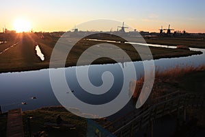 Romantic sunset in red and yellow colors. the plain of the rural countryside of zaanse schans with its typical Dutch mills