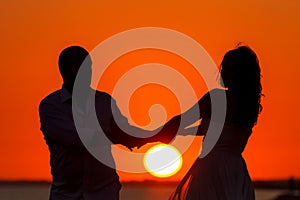 Romantic sunset and silhouettes of lovers