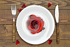 Romantic table setting. Red rose on empty plate