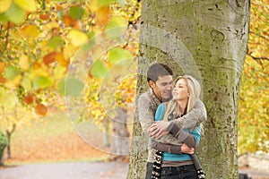 Romantic Teenage Couple By Tree In Autumn Park