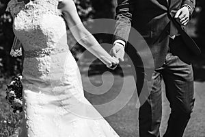 Romantic touch. gorgeous bride and groom embracing and holding hands. black white photo. romantic moment. happy wedding couple