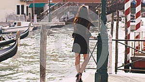 Romantic tourist woman on pier against beautiful view on venetian chanal in Venice, Italy.