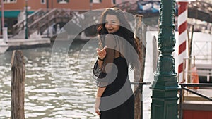 Romantic tourist woman on pier against beautiful view on venetian chanal in Venice, Italy.