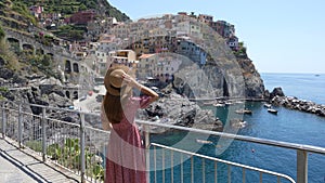 Romantic trail in Italy. Rear view of pretty girl walking on the promenade towards Manarola village, Italy.