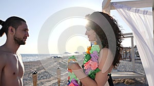 Romantic vacation for loving couple by sea, Hawaii lei are put on neck of guy and girl, Sunny beach tropical island for